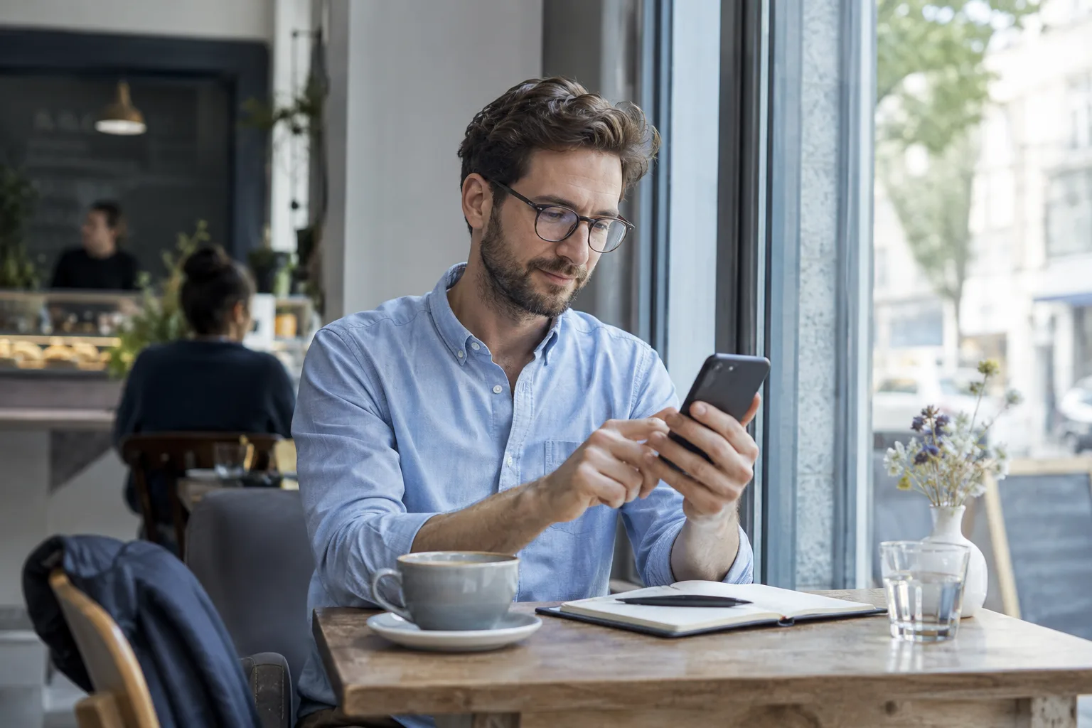 Wann werden Tagesgeld-Zinsen gutgeschrieben? Person prüft ihre Finanzen unterwegs am Smartphone.